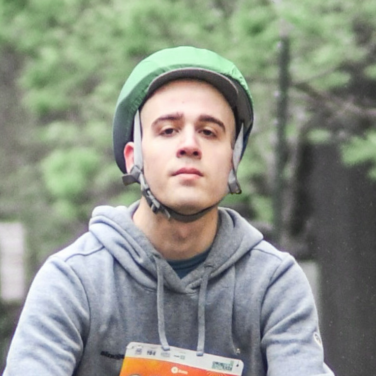 a headshot of a man riding a bike looking down at a slight angle into the camera.